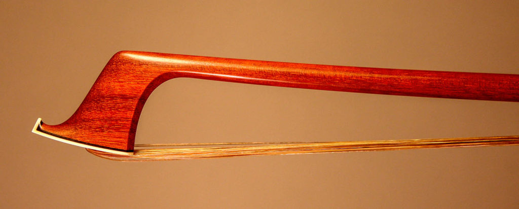 Violin Bow with a round pernambuco stick, silver-mounted ebony frog with double pearl eyes and divided button. Personal model inspired by Pajeot.  